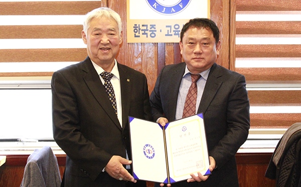 박상구 선관위원장이 한국중·고육상연맹 제20대 회장에 당선된 홍순철(오른쪽) 회장에게 당선증을 전달하고 있다.