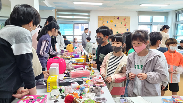 동광초 학생들이 자원순환 실천을 위해 마련한 공유곳간에서  물품을 나누고 있다.