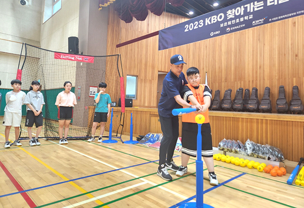 송진우 코치가 회인초를 찾아 학생들에게 티볼치는법을 알려주고 있다.