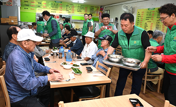 고정식 직장새마을운동보은군협의회 회장과 회원들이 어르신들께 말복 음식을 제공하고 있다.