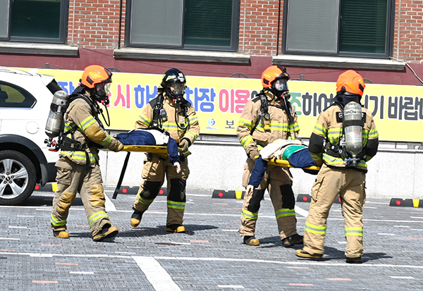 화재현장에 돌입한 긴급구조대원들이 환자를 이송하고 있다.
