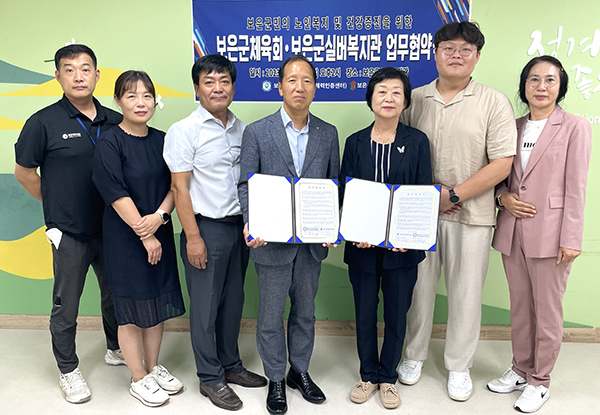 윤갑진 회장과 고은자 관장이 업무협약서를 교환하고 있다.