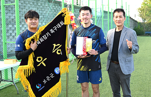 족구대회에서 우승을 차지한 세움팀이 오쾌철 회장으로부터 우승컵과 우승기를 받아 들어 보이고 있다.