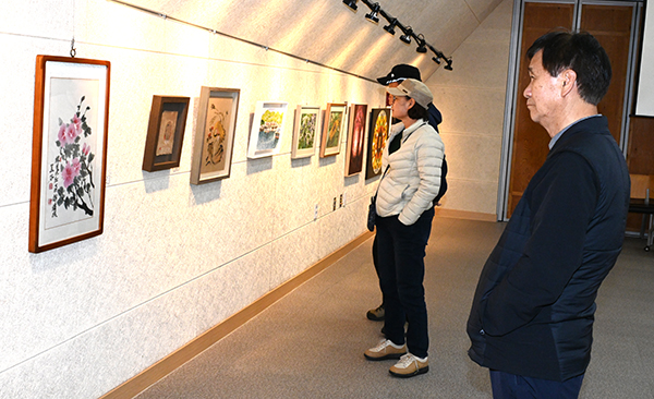 속리산 관문갤러리를 찾은 관광객들이 보은미술협회 정기전에 출품된 작품을 감상하고 있다.