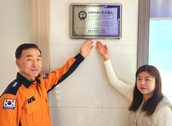 박종근 보은소방서 예방안전과장이 우주스크린골프장을 방문해 김선미 대표와 함께 우수업소 인증표지를 부착하고 있다.