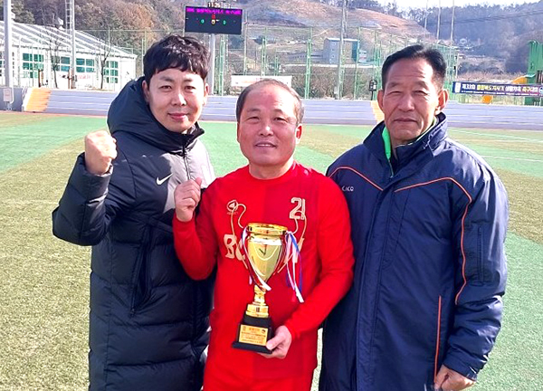 서동현 선수가 박진섭(좌) 보은군축구협회장, 김인수(우) 보은60FC회장과 함께 트로피를 들어올리고 있다.