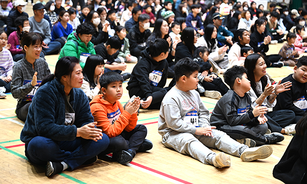 아이들과 엄마가 활짝 웃으며 응원의 박수를 보내고 있다.