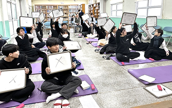 회인중 학생들이 독서 골든벨을 통해 선생님이 낸 문제에 ○X를 들어 답하고 있다.