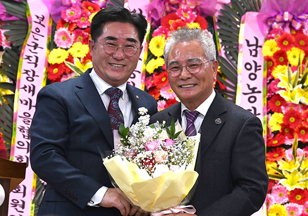 정영원 이임회장이 김원경 신임회장에게 취임을 축하하며 꽃다발은 전하고 있다.