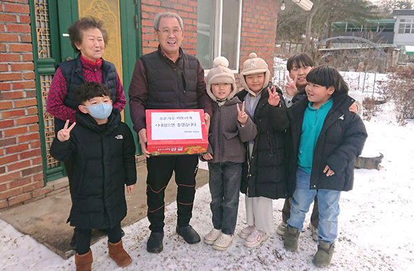 부룡관합기도 아동들이 홀몸어르신께 후원물품을 전달하며 행복을 기원하고 있다.