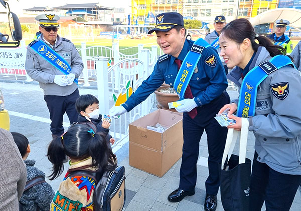 관계자들이 어린이들에게 홍보용품 나눠주며 교통안전 캠페인을 펼치고 있다.