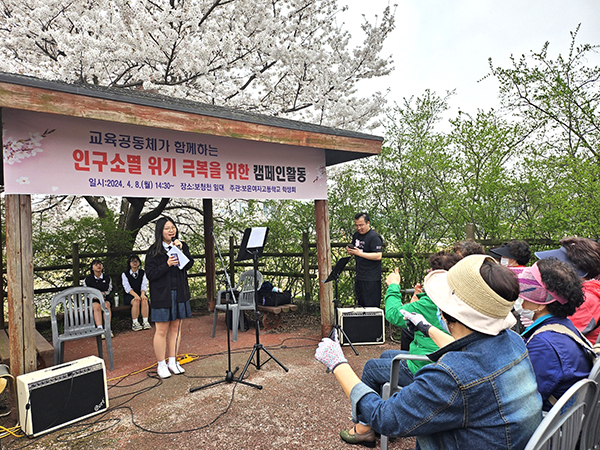 보은여고 학생들이 벚꽃 만개한 보청천을 찾아 인구 소멸 위기 극복을 위한 캠페인을 펼치고 있다. 