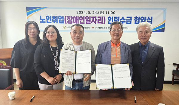 이범로 노인회장과 권헌중 장애인연합회장이 노인장애인 일자리 알선 업무협약서를 교환하고 있다.