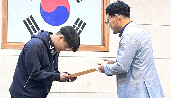 사격대회에서 은상과 동상을 받은 이인혁 학생이 김진환 교장으로부터 상장을 받고 있다.