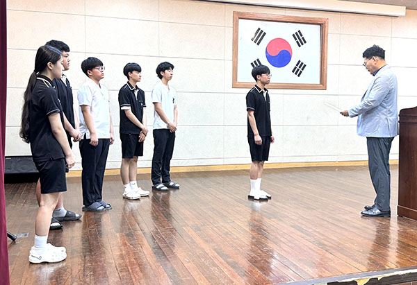 김진환 보은고 교장이 5명의 장학생에게 장학금을 전달하고 있다.