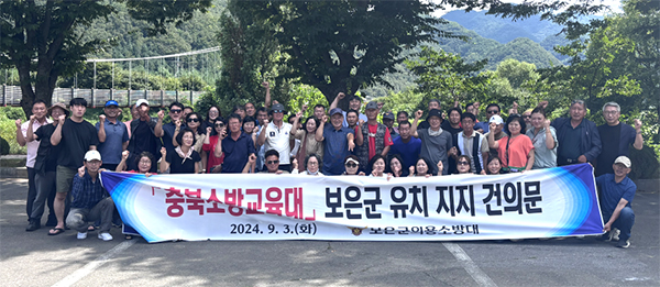 보은군 의용소방대원들이 충북소방교육대 보은군 유치를 응원하는 건의문을 채택 후 단체사진을 찍고 있다.