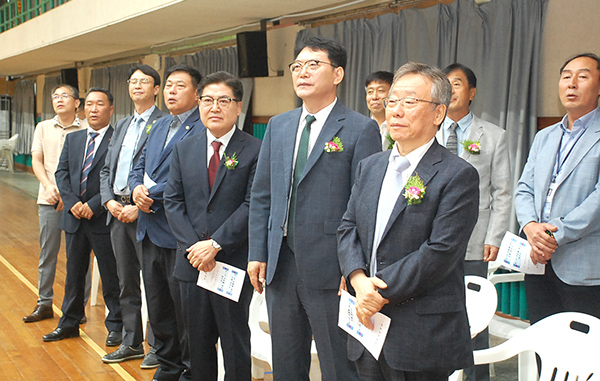 이임하는 김진환 교장과 취임하는 윤여찬 교장이 내빈과 함께 국민의례를 갖고 있다.