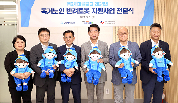 독거노인 반려로봇 지원사업 전달식에서 새마을금고와 보은군 관계자들이 효돌이를 안고 있는 모습. /제공 보은군