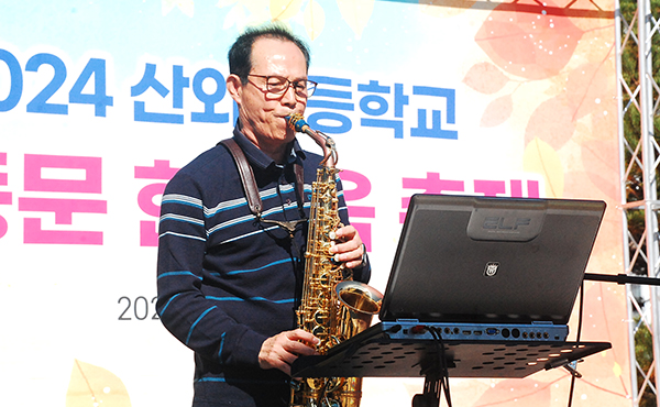 구연책 동문이 색소폰 연주를 동문들에게 선사하고 있다.