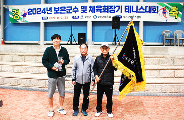 우승을 차지한 보은테니스클럽이 우승컵과 우승기를 자랑하고 있다.