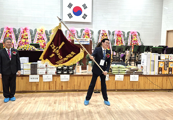 보은중학교총동문회 이태영 취임 회장이 동문회기를 전달받고 있다.