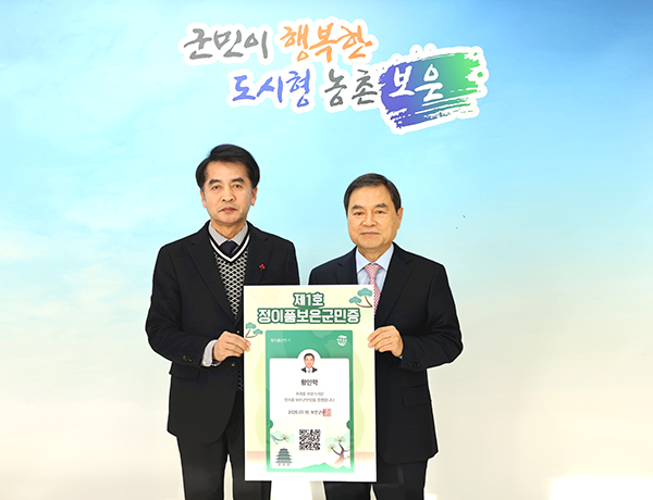 제1호 정이품보은군민 주인공으로 선정된 황인학 재경보은군민회장(좌측)이 최재형 군수로부터 정이품보은군민증을 발급받고 기념촬영을 하고 있다.