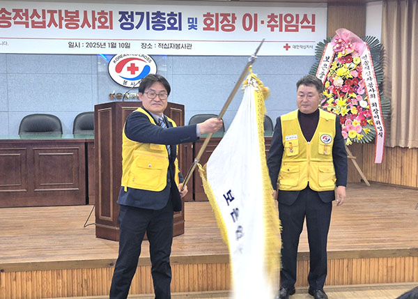 연송적십자봉사회 기를 전달받은 홍성직 취임회장이 기를 흔들고 있다.
