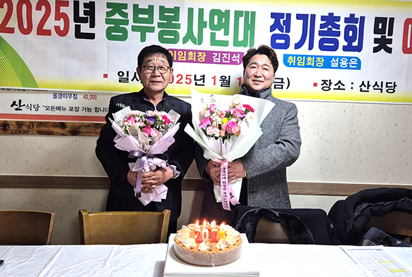 설용은 취임 회장과 김진석 이임 회장이 서로를 격려하고 있다.