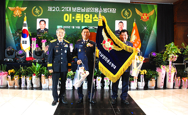 강문수 대장이 김영준 소방서장과 최종호 이임대장으로부터 보은남성의용소방대기를 전달받고 있다.