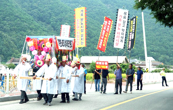 가축분뇨처리시설 건립에 반대하는 주민들이 장안면민의 날 한마음 대잔치가 열리는 장안면행정복지센터 앞에서 행여를 메고 시위를 하고 있다.
