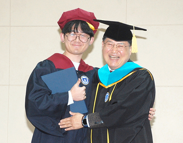 보은고 윤여찬 교장이 졸업장을 전달하며 포옹하고 있다.