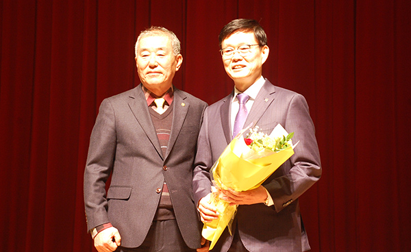 정경재 후보가 구왕회 원장으로부터 당선 축하 꽃다발을 전달받고 있다.