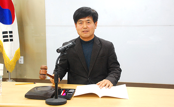 신현호 회장이 의사봉을 두드리며 원안 가결을 선언하고 있다.