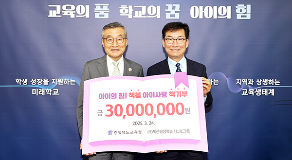 김상문 인광그룹회장이 충북교육청 윤건영 교육감에게 도서구입비를 전달하고 있다.