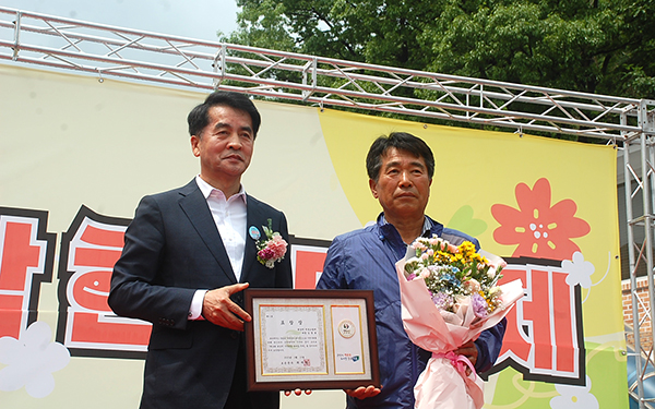 최재형 군수가 김영봉 회남면의용소방대장에게 표창장을 전달하고 있다.