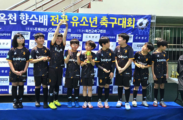 보은스포츠클럽 소년축구클럽팀이 준우승 트로피를 들어 올려 자랑하고 있다.