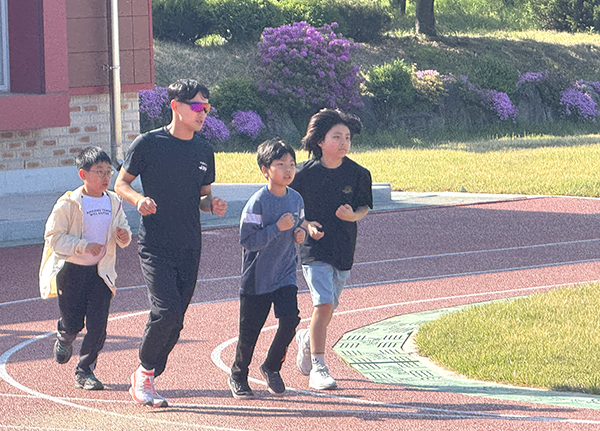 판동초 학생들이 등교를 하자마자 선생님과 함께 운동장을 달리고 있다.