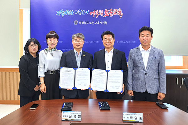 박형준 보은자동차공업사 대표와 전병일 교육장이 업무협약을 체결하고 협약서를 교환하고 있다.