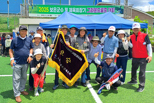 탄부그라운드클럽 회원들이 우승기를 들어 올리며 승리감을 만끽하고 있다.