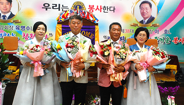 꽃다발을 든 육명수 이임회장과 이호 취임 회장 부부가 하객들에게 감사를 표를 하고 있다.