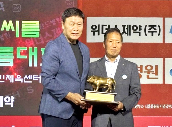 윤갑진 보은군체육회장이 이준희 대한씨름협회장으로부터 감사패를 받아들고 있다.
