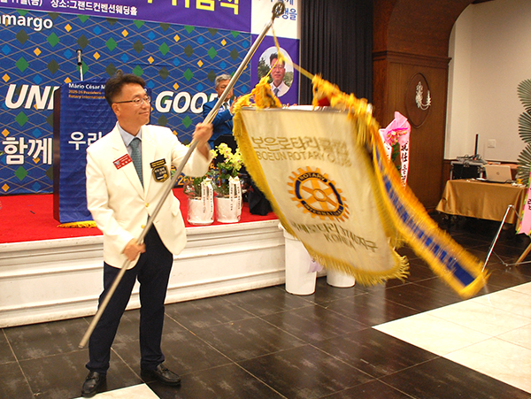 동보 김성구 회장이 보은로타리클럽 기를 휘두르며 의욕을 표출하고 있다.