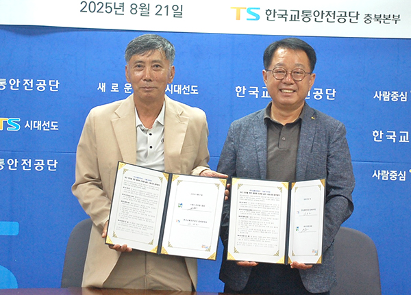 전진호 한국교통안전공단 충북본부장과 박병인 에스라이팅 대표가 업무협약서를 교환하고 있다.