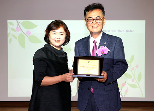 김흥준 국제교육원장이 충북국제교육원 직원들이 마련한 송공패를 전달받고 있다.