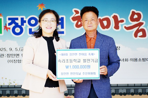 윤윤용 장안면 한마음추진위원장이 속리초 문은경 교장에게 학교 발전기금을 전달하고 있다.