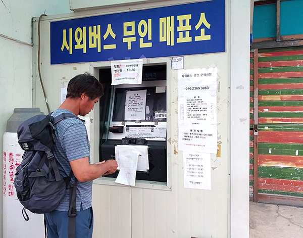 북부매표소가 폐쇄된 줄 모르고 보은군 양계농장에서 근무하는 한 외국인 근로자가 22일 청주가는 표를 구하기 위해 무인 승차권 발매기를 이용하고 있다.