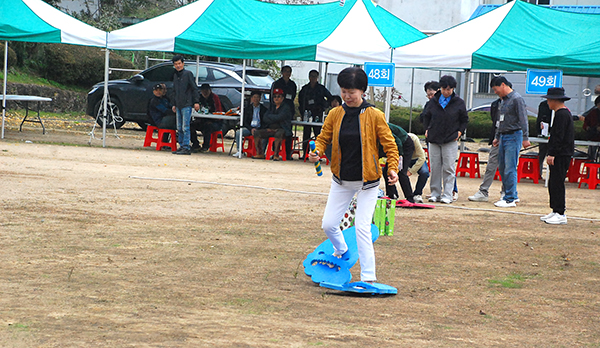 동문회에 참여한 동문들이 ‘초대형 슬리퍼 신고 달리기’에서 헛발을 내딕고 잇다.