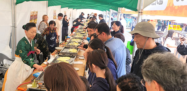 공영주차장에 마련된 미식페스티벌에서 관람객들과 쉐프들이 밀키트 철판에서 부추전을 만드는 모습. /제공 보은군