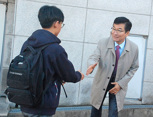 보은고를 찾은 윤건영 교육감이 등교하는 학생들을 맞이하고 있다.