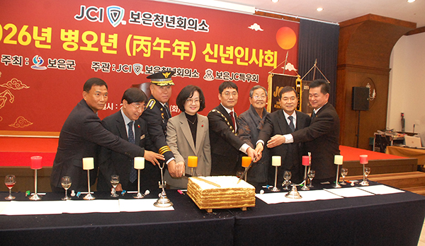 신년 인사회에 나온 이들이 군민의 행복을 기원하며 떡을 자르고 있다.